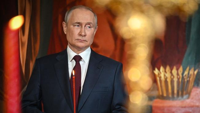 Russian President Vladimir Putin holds a candle during an Orthodox Easter service. Photo by Alexander NEMENOV / AFP