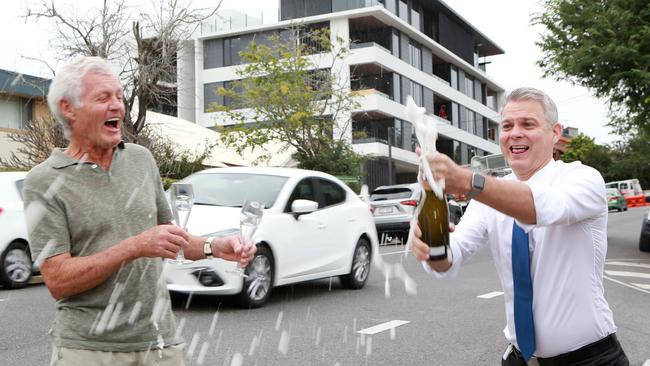 Resident Gervase Griffith and Councillor James Mackay pop the champers after news broke that the speed limit on dangerous Swann Rd at Taringa will drop to 50kmh. Picture: AAP/Sarah Marshall