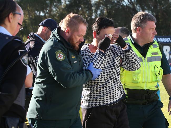 A female protestor was restrained and then treated by security and ambulance paramedics after dousing herself in a flammable liquid outside Parliament House in Canberra. Picture Kym Smith