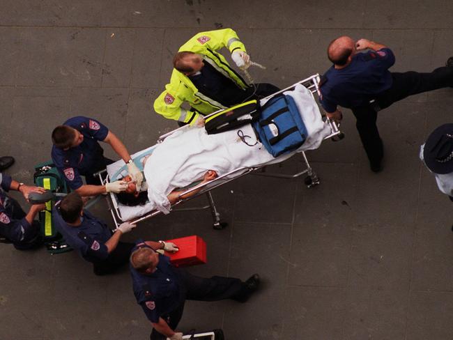 Paramedics remove the critically-injured Pin Siv Eng from the building.