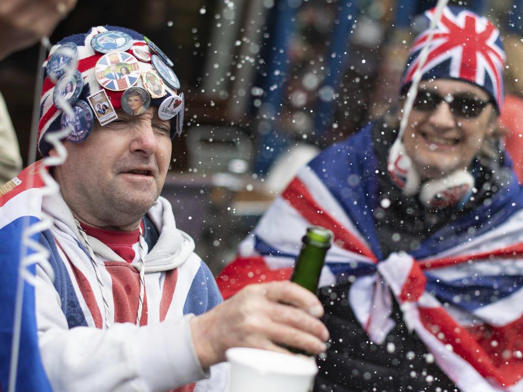 Royal fans celebrate with champagne outside Windsor Castle after Buckingham Palace announced the news of the birth. Picture: Dominic Lipinski/PA via AP