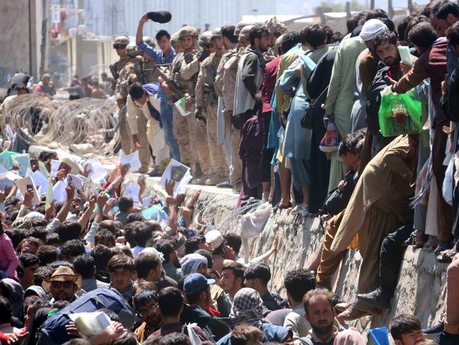 Afghans struggle to reach the foreign forces to show their credentials to flee the country outside the Hamid Karzai International Airport, in Kabul.