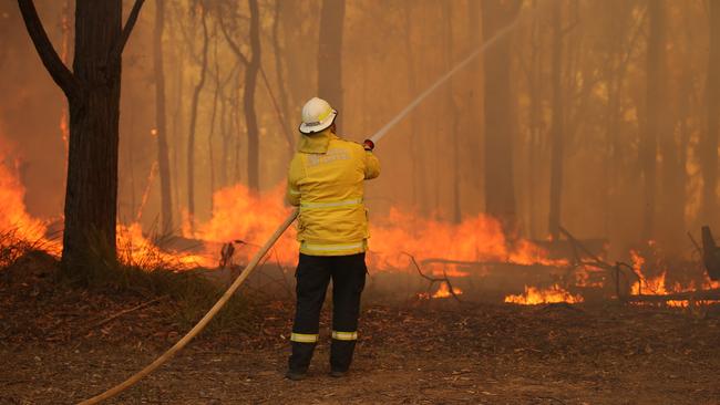 Firefighters protect properties Tuesday afternoon as the fire advanced through the bush at Colo Heights. Picture: Rohan Kelly