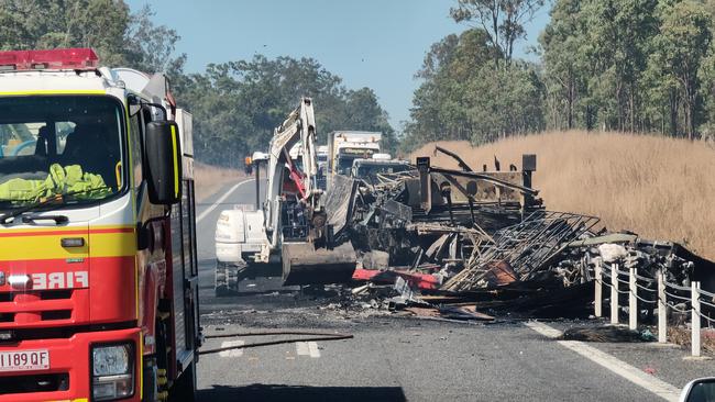 Claytons towing use an excavator to clear the charred remains of a semi trailer sitting on the Bruce Highway, 37km south of Miriam Vale, after a two truck crash on August 5, at 11.15pm. Picture Rodney Stevens