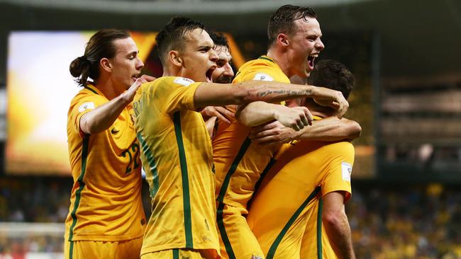Mathew Leckie of the Socceroos celebrates with team mates after scoring against UAE.