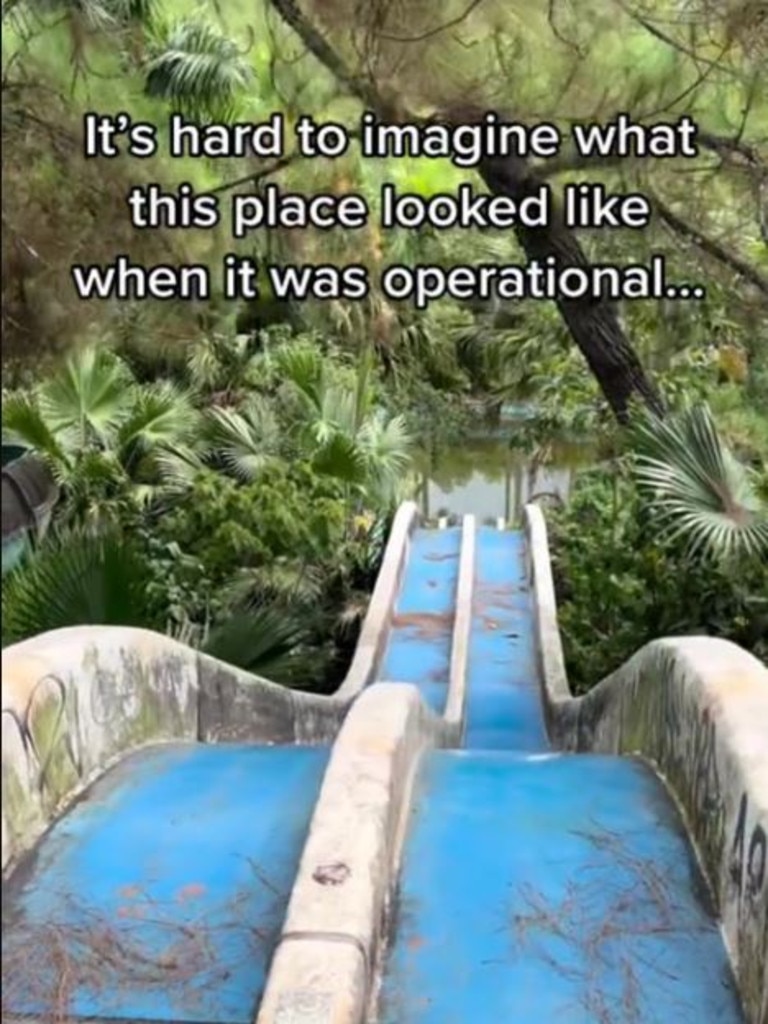 A double water slide sits vacant and filthy.