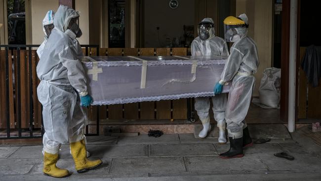 Volunteers remove the body of a woman suspected to have died from Covid-19 from a home in Yogyakarta. Picture: Getty Images.