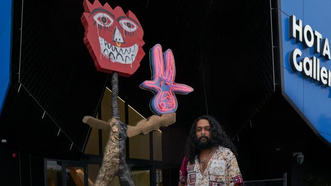 Artist Ramesh Mario Nithiyendran with his sculpture at the entrance of the new HOTA Gallery. Photo: Alex Chomciz.