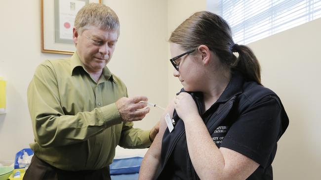 Glenorchy GP Gerard McGushin administers a vaccine at the Glenorchy medical Centre. Picture: MATHEW FARRELL