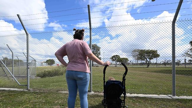 Kristen, who has been couch surfing for the past year, outside the barbed wire fence around the newly finished Pinkenba quarantine facility. Pic: Lyndon Mechielsen/Courier Mail