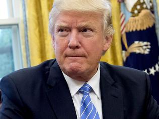 US President Donald Trump prepares to sign several executive orders in the Oval Office of the White House in Washington, DC, January 23, 2017. Trump on Monday signed three orders on withdrawing the US from the Trans-Pacific Partnership trade deal, freezing the hiring of federal workers and hitting foreign NGOs that help with abortion. / AFP PHOTO / SAUL LOEB