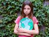 Sad cute girl holding planet model - climate change anxiety