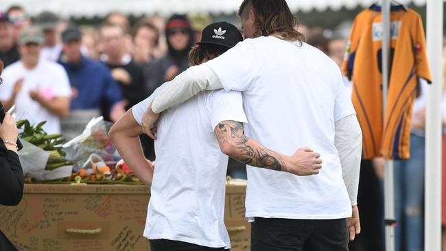 Friends and family comfort each other during the memorial service for the popular Mullumbimby Moonshiners Rugby Club player.