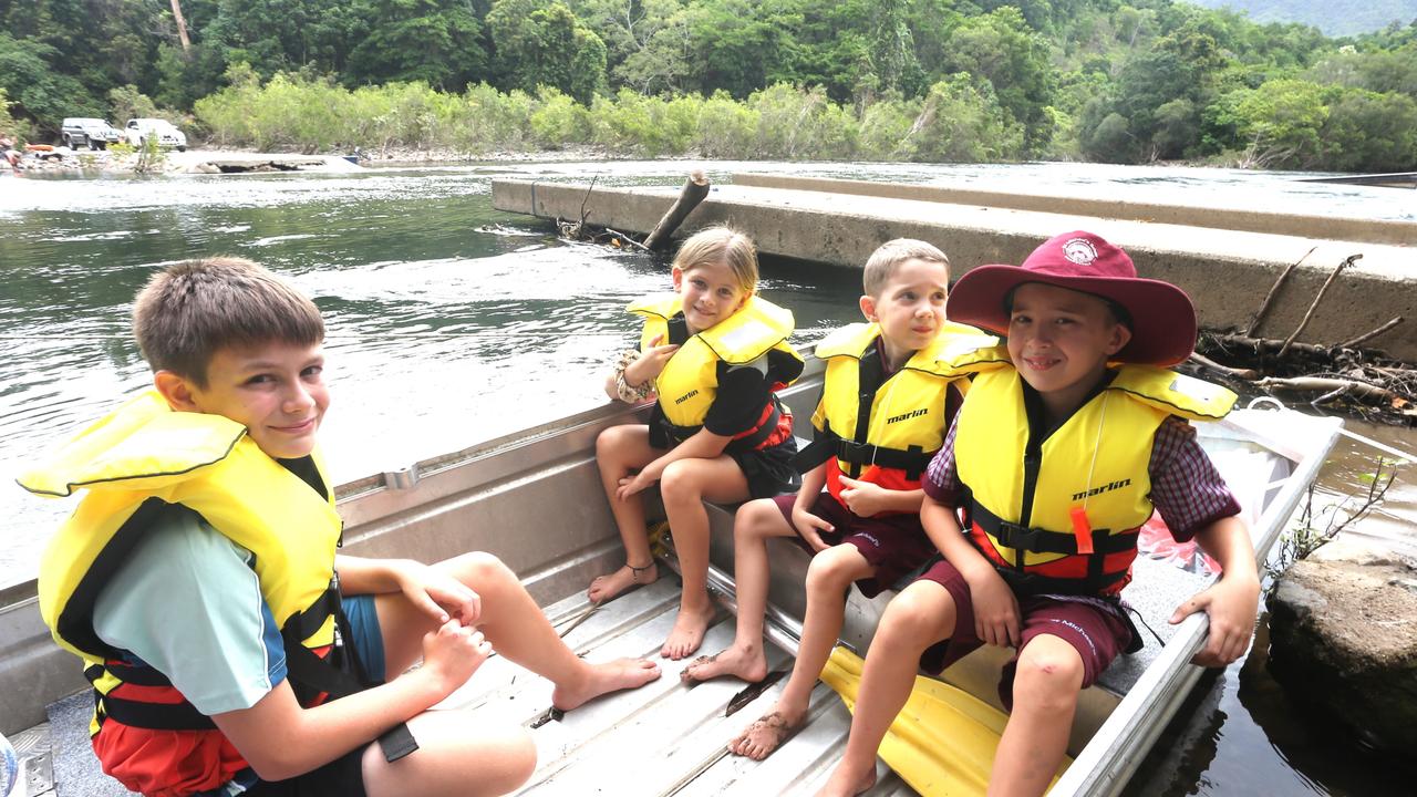 Gordonvale State High School student, Gordonvale Primary School student Kyrah with St Michaels School pupils Rubus and Archer McKowens cross the Mulgrave River after the Fisheries Bridge was washed away by flood water. Picture: Peter Carruthers