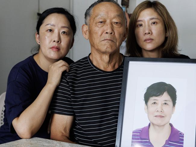 Yaqin Han’s daughters Na Xue and Fei Xue and husband Zumu Xue with a photograph of their beloved family member. Picture Lachie Millard