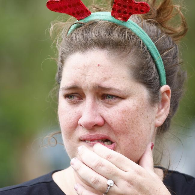 Shae Curr-Parkes nervously awaits news from family members stranded by floodwaters at Holloways Beach. Picture: Brendan Radke