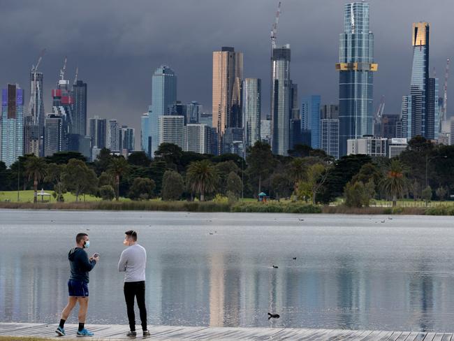 MELBOURNE, AUSTRALIA - NewsWire Photos AUGUST 19, 2020: A couple stop to photograph the Melbourne city skyline from Albert Park Lake as a wintery storm passes over the city. Picture: NCA NewsWire / Andrew Henshaw