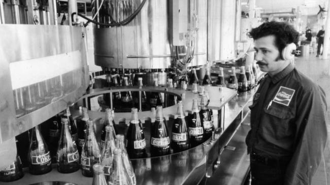 View of worker looking over bottles filling with Coca-Cola on the $1 million dollar bottling line, which was installed in 1973 at the Thebarton factory of C-C Bottlers, Adelaide, SA. Used 21 Aug 1975.