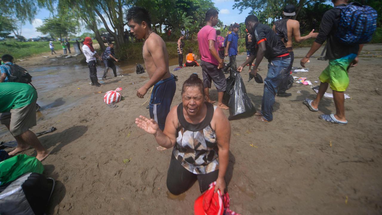 A migrant reacts after crossing the Suchiate River between Guatemala and Mexico, after a security fence on the international bridge was reinforced to prevent people passing through. Picture: Johan Ordonez/AFP
