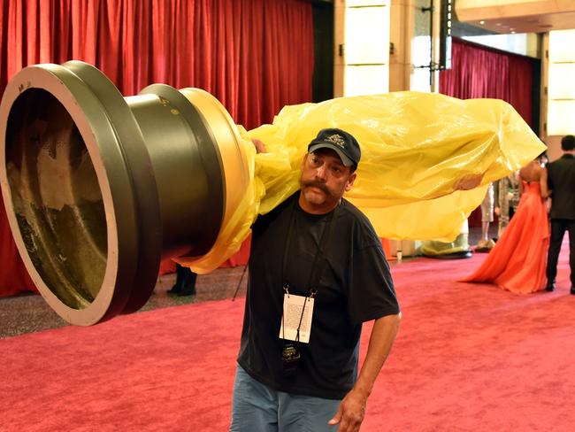 A worker carries an Oscar statue at the red carpet outside Dolby Theatre as preparations are underway for the 87th annual Academy Awards in Hollywood, California on February 21, 2015. The 87th Oscars take place on February 22 at Hollywood's Dolby Theatre. AFP PHOTO/MLADEN ANTONOV