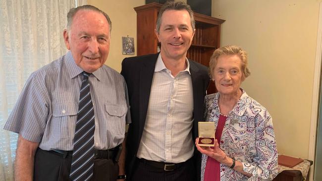 Brian and Fleur Wenham, who is holding the 1956 Olympic gold medal, with Blaxland MP Jason Clare. 