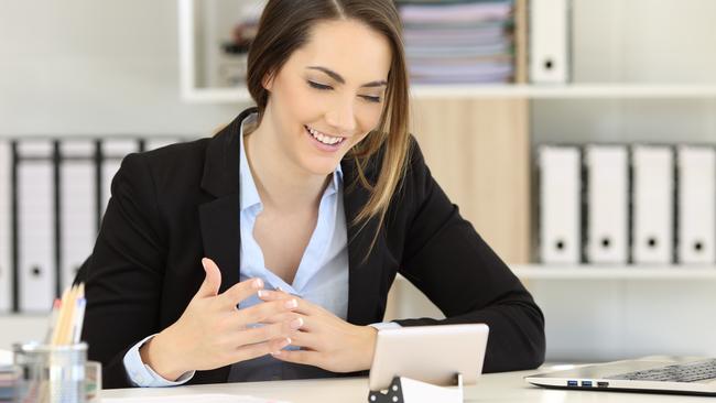 CAREERS: Office worker having a video call with a smart phone on a desktop