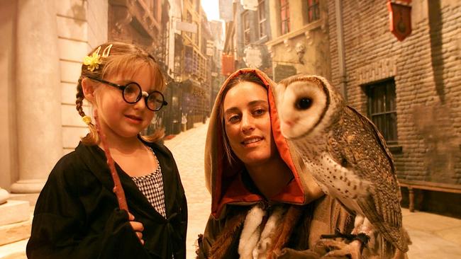 Harry Potter Movie magic experience at Movie World where Janieka Mallon meets ‘Clark’ the owl with handler Melissa Spittall in Diagon Alley. Picture: Geoff McLachlan