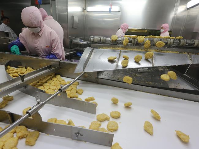 Workers producing food at the Shanghai Husi Food Co. Shanghai city officials have shut a Shanghai Husi factory of US food provider OSI Group for selling out-of-date meat to restaurant giants.