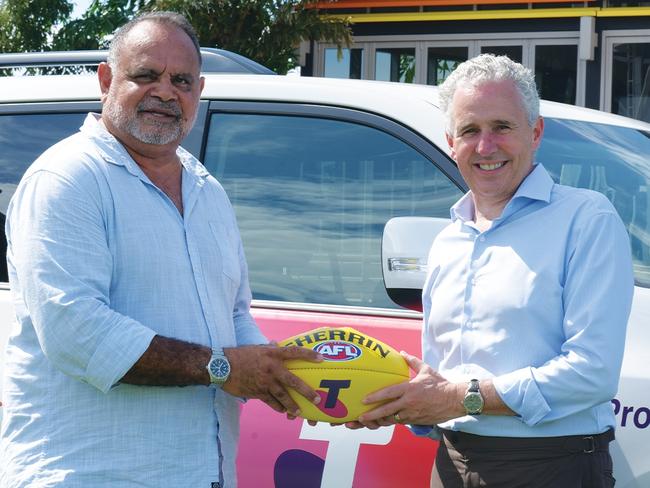 The Michael Long Foundation has received two new Toyota 4WD vehicles. Territory footy legend Michael Long is pictured with Telstra CEO Andrew Penn.