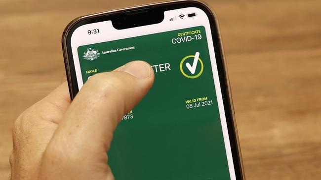SYDNEY, AUSTRALIA - OCTOBER 14: In this photo illustration a man holds a phone displaying a valid Australian digital COVID-19 certificate on October 14, 2021 in Sydney, Australia. Australians are downloading digital COVID-19 vaccine certificates to prove their vaccination status as restrictions ease for people who are fully vaccinated against the coronavirus. (Photo illustration by Cameron Spencer/Getty Images)