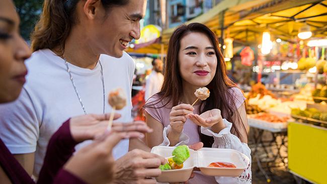 Friends eating local cuisine at a night market. Picture: iStock