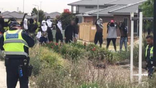 A group of youths point their middle fingers at police.