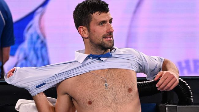 Serbia's Novak Djokovic changes his shirt during a break in his men's singles match against Croatia's Dino Prizmic on day one of the Australian Open tennis tournament in Melbourne on January 14, 2024. (Photo by WILLIAM WEST / AFP) / -- IMAGE RESTRICTED TO EDITORIAL USE - STRICTLY NO COMMERCIAL USE --