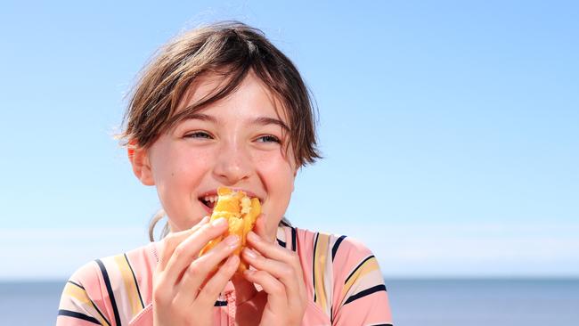 Mia Sherlock, 9, eats hot chips on the Cairns Esplanade. Picture: Brendan Radke