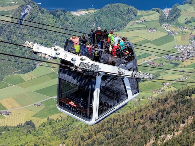 Stans, Switzerland - 7 May, 2016: people in a gondola of the Stanserhorn Cabrio cable car. Stanserhorn Cabrio is the the world's first double deck open top cable car, it carries 60 passengers per cabin with room for 30 on the open deck. Stanserhorn is a mountain in Switzerland, located in the canton of Nidwalden near to the border with Obwalden, with the peak at 1,898 meters above sea level.