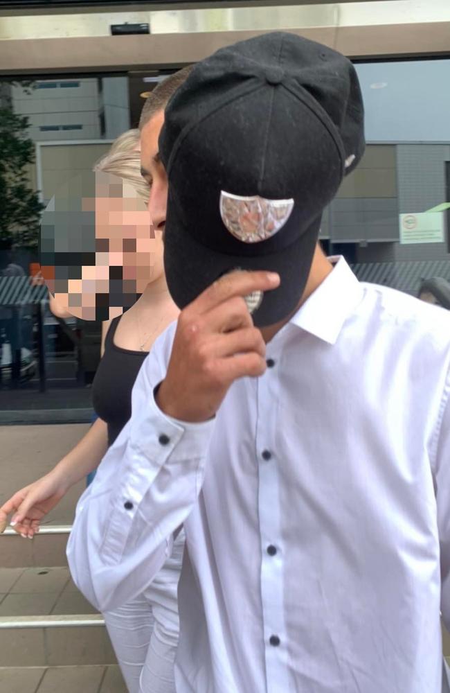 Cantarella covering his face with a hat while leaving Maroochydore Magistrates Court in 2022.