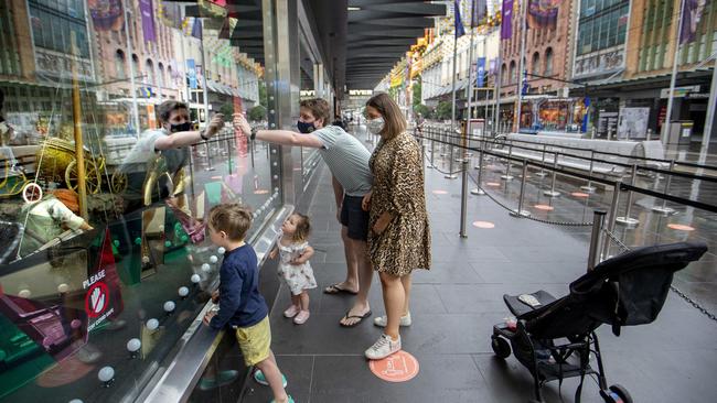 A family in masks at the Myer Christmas windows early Sunday morning. Picture: NCA NewsWire/David Geraghty