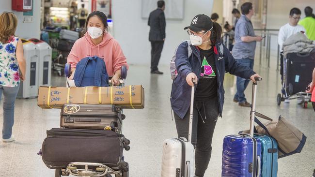 Chinese travellers wearing masks at Melbourne Airport. Picture: Rob Leeson.