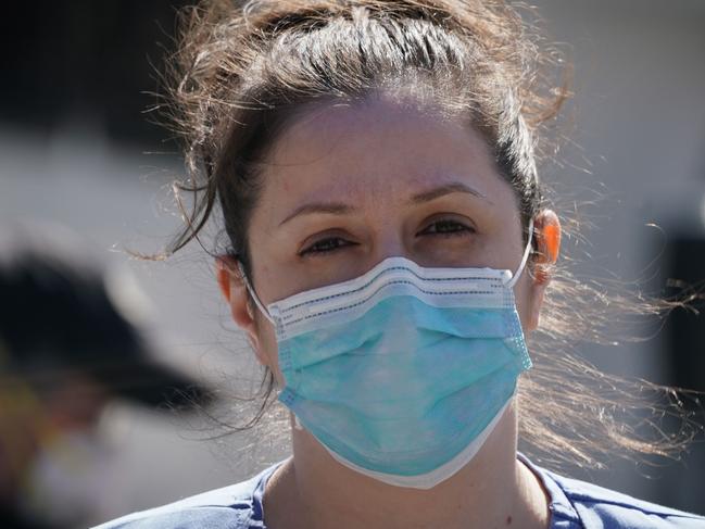 A member of the medical staff listens as Montefiore Medical Center nurses call for N95 masks and other ‘critical’ PPE to handle the coronavirus (COVID-19) pandemic on April 1, 2020 in New York. - The nurses claim "hospital management is asking nurses to reuse disposable N95s after long shifts" in the Bronx. (Photo by Bryan R. Smith / AFP)