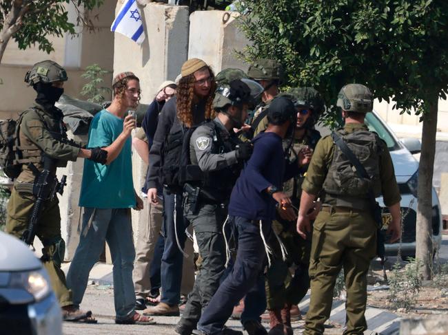 Israeli soldiers restrain Jewish settlers after they stormed the Palestinian West Bank village of Dayr Sharaf following the death of an Israeli man. Picture: AFP