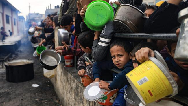 Palestinians children wait to collect food at a donation point in a refugee camp in Rafah. Picture: Mahmud Hams/AFP