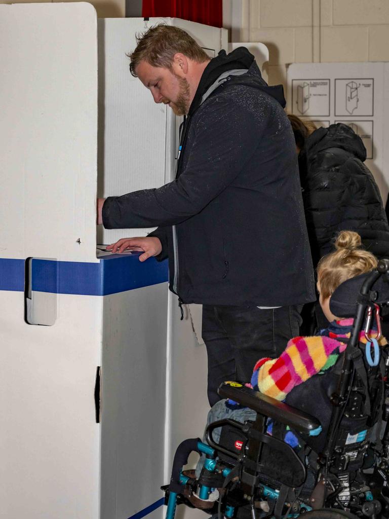 Luke Edmunds accompanied by his family voting at Bellerive Primary School. Picture: Caroline Tan