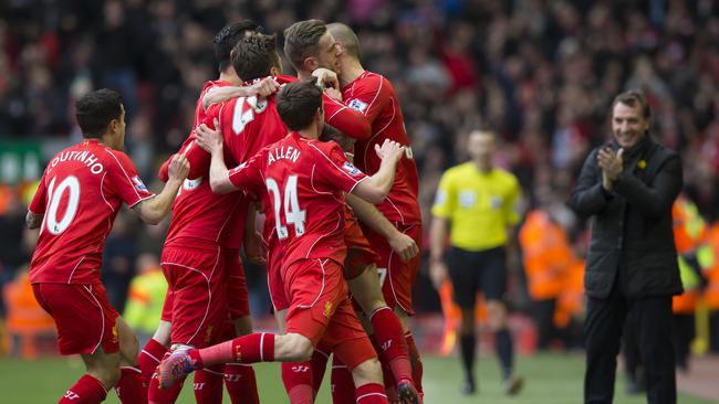 As manager Brendan Rodgers, right, applauds Liverpool's Jordan Henderson.