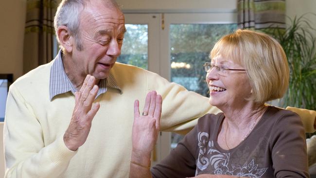 senior couple sorting finances; happy retirees high-five money and superannuation generic