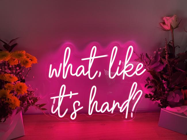 The famous "What, like it's hard?" quote from Legally Blonde in neon hangs in Laura Santin's home. Photo: Laura Santin