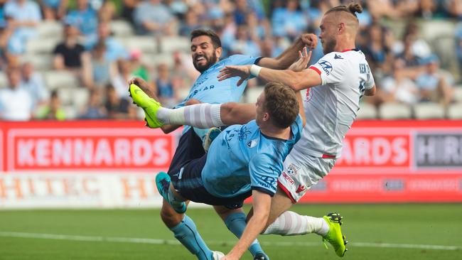 Adelaide’s Ken Ilso has a shot blocked by Michael Zullo and Aaron Calver on Sunday night. Picture: AAP.