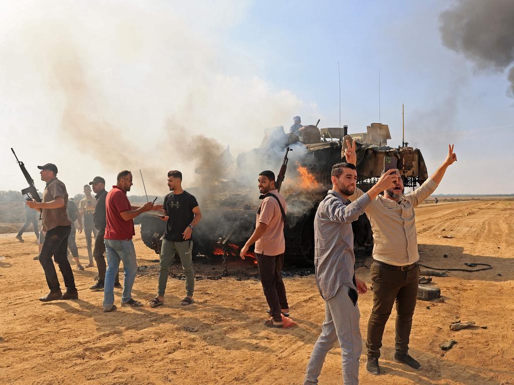 Palestinians take selfies after taking control of an Israeli tank at the border fence with Israel from Khan Yunis. Picture: AFP