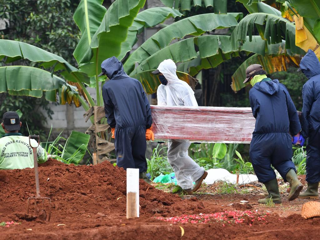 Gravediggers carrying the coffin of a victim of the COVID-19 coronavirus at a cemetery near Jakarta. Picture: AFP