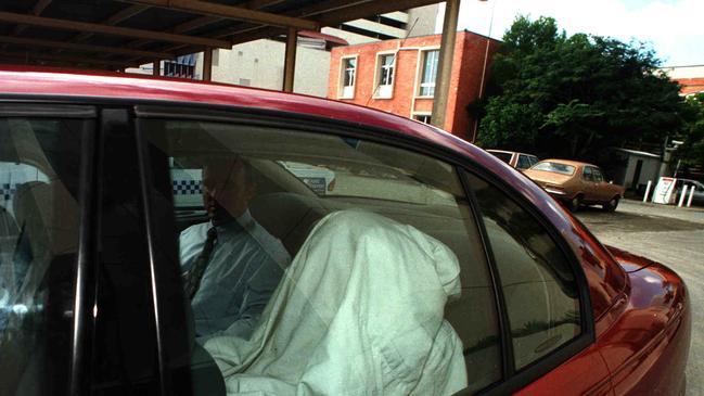 Kevin Baggott hides under a blanket as he is taken from Southport Court after being charged with the murder of his estranged wife Michelle. Picture: Paul Riley