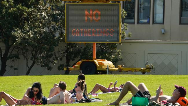 People sunbathe on the lawns near St Kilda beach yesterday. Picture: AAP Image/Scott Barbour